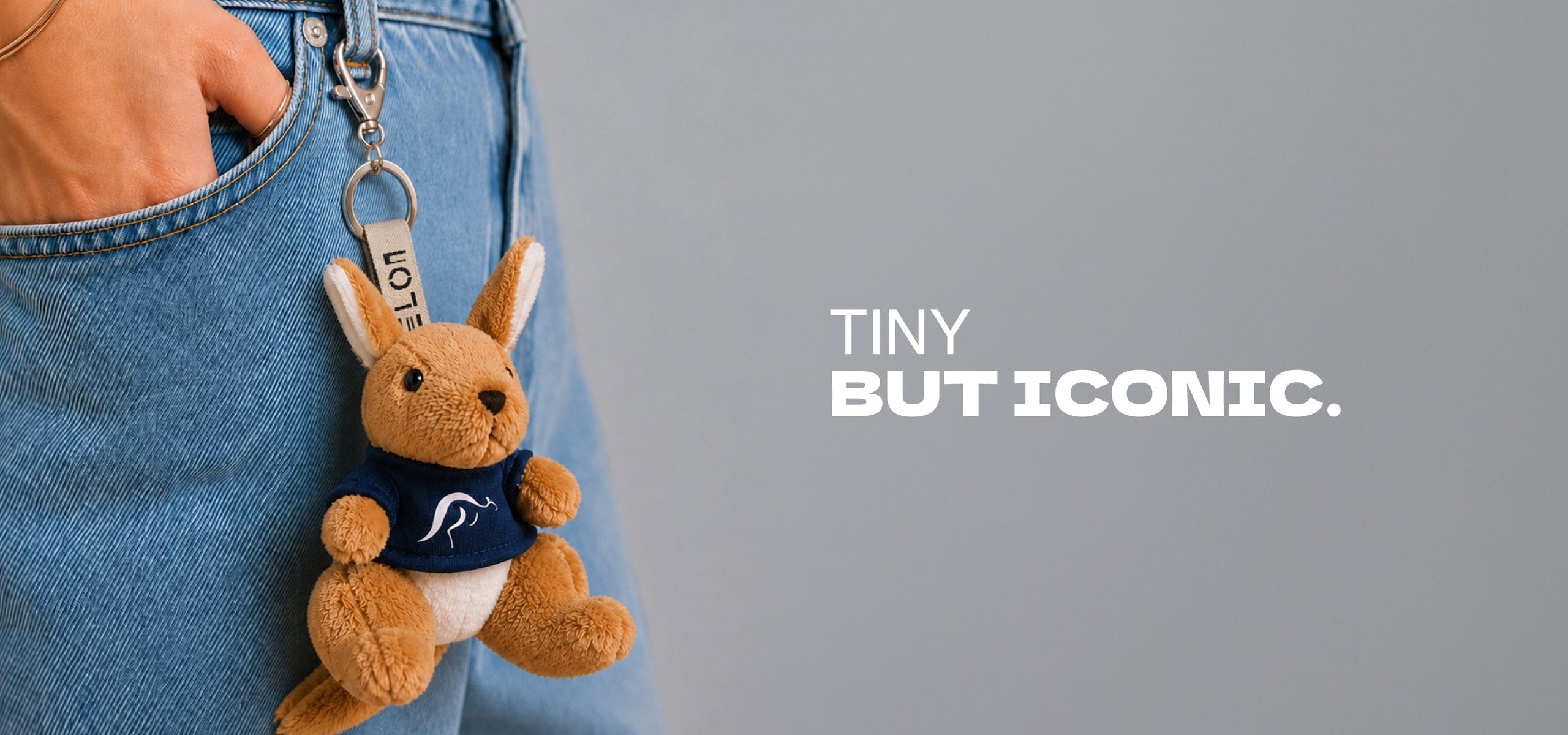 Melon kangaroo keyring on denim. Tiny but iconic.