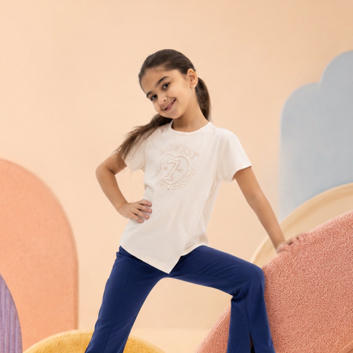Girl in a white Melon top and navy trousers
